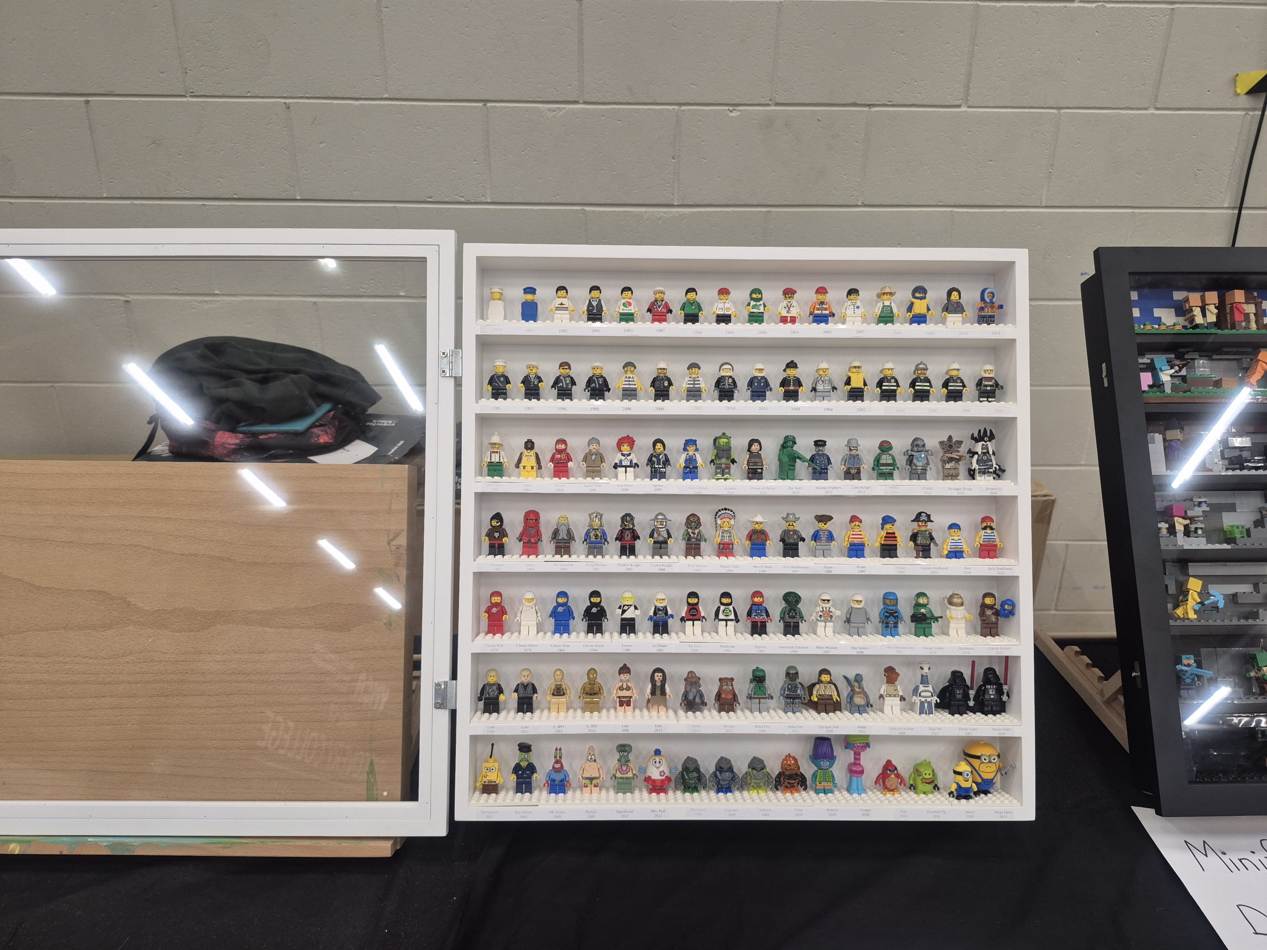 Close-up of the Digs for Figs History of the Minifig display frame, showing minifigures arranged by year from 1975 to today