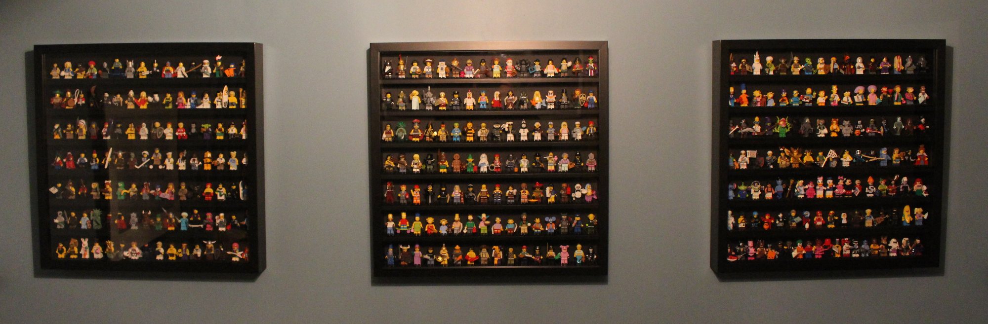 Three black front-opening minifigure display frames mounted on a wall