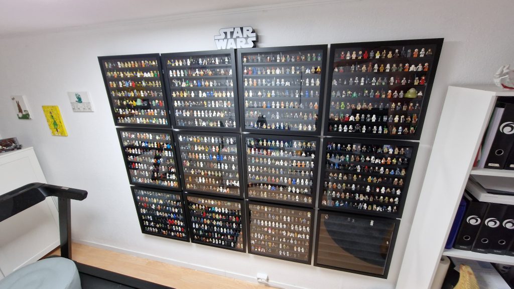 LEGO minifigure collection arranged across shelves in a wall-mounted display frame.